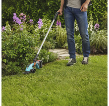 Mann verwendet Akku-Grasschere mit Stiel im Garten