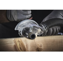 Eine Nutfräse in Aktion beim Fräsen eines Holzstücks mit Staubabsaugung.