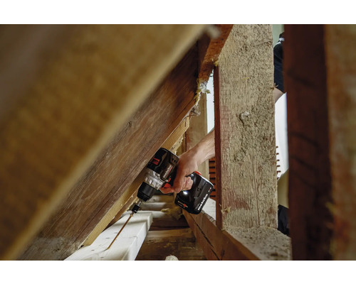 Eine Person schraubt mit einem Metabo Akku-Bohrschrauber eine Schraube in ein Holzbrett.