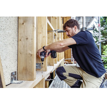 Handwerker arbeitet mit einem Akku-Bohrschrauber an einer Holzkonstruktion