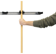 Mann befestigt Stiel in Wandhalterung für Werkzeuge