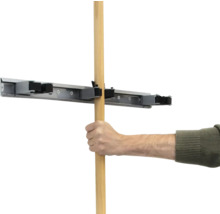 Eine Hand führt einen Holzstiel in eine Gerätehalterung ein.