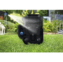 Reinigung eines Rasenmähroboters mit Wasserstrahl auf einer Rasenfläche