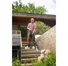 Mann reinigt Treppe mit Hochdruckreiniger im Außenbereich.