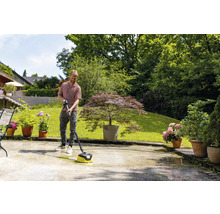 Mann reinigt Terrasse mit Flächenreiniger