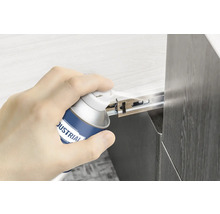 Eine Hand sprüht Gleitspray auf einen Schubladenauszug.