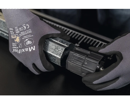 Hände mit Schutzhandschuhen montieren einen Rolladenkasten