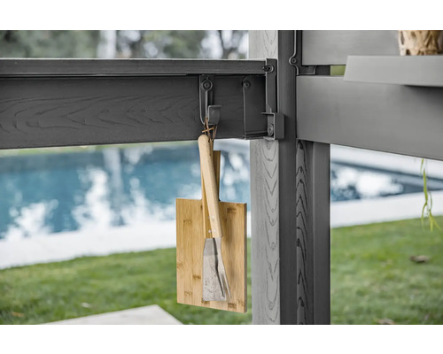 Bambus Schneidebrett und Grillbesteck hängen an einer Terrassenüberdachung