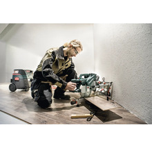 Handwerker mit Metabo Kapp- und Gehrungssäge beim Laminat schneiden in einem Raum.