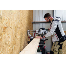 Ein Mann schneidet ein Holzbrett mit einer Metabo Kapp- und Gehrungssäge.