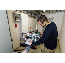 Ein Mann mit Schutzbrille und Gehörschutz arbeitet mit einer Metabo Kappsäge an einem Werkstück.