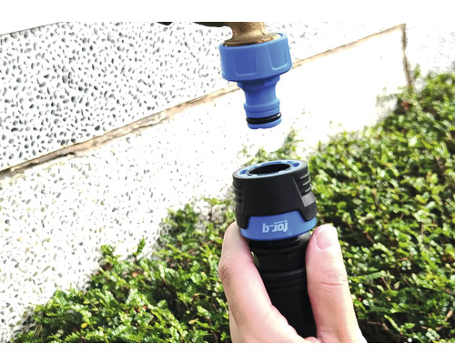 Gartenschlauchkupplung wird an Wasserhahn angeschlossen