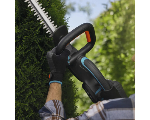 Person schneidet Hecke mit Akku-Heckenschere von Gardena