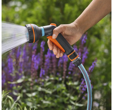Gartenbrause mit Wasserstrahl in der Hand