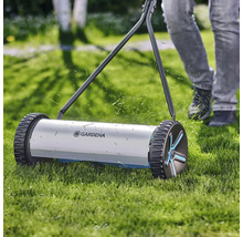 Handrasenmäher im Einsatz auf Rasenfläche mit Gardena Logo