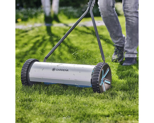 Handrasenmäher im Einsatz auf Rasenfläche mit Gardena Logo