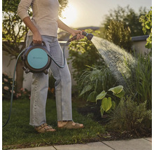 Frau bewässert Garten mit Gardena Schlauchbox