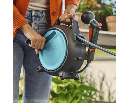Garten Schlauchbox mit Schlauch und Spritze in der Hand
