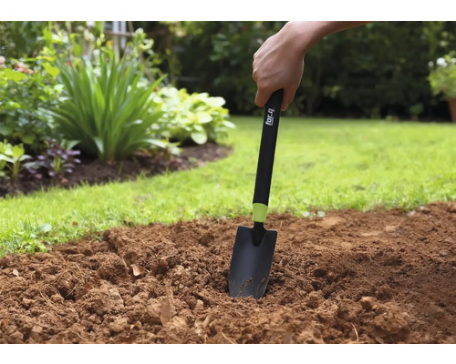Gartenarbeit mit einer Handschaufel im Gartenbeet