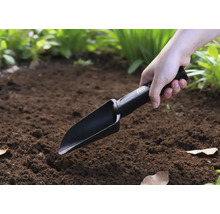 Eine Person benutzt eine Handschaufel im Garten.