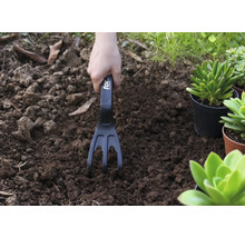 Gartenarbeit mit einer Gartenkralle in der Erde
