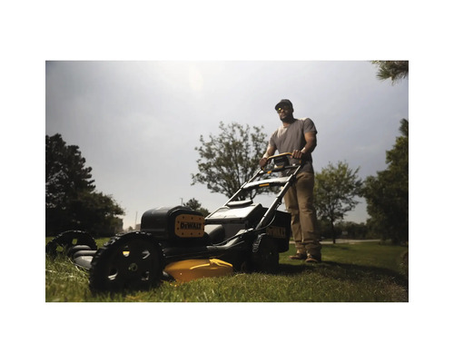 Ein Mann bedient einen Rasenmäher der Marke DeWalt auf einer Rasenfläche.