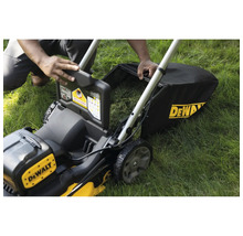 Rasenmäher mit Fangkorb wird von einer Person auf einer Rasenfläche bedient.