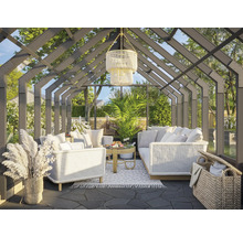 Terrasse mit Gartenmöbeln unter einem Glasdach