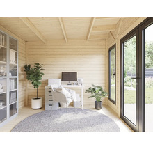 Helles Gartenhaus eingerichtet als Büro mit Schreibtisch, Stuhl, Regalen und Pflanzen.