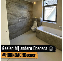 Badezimmer mit Badewanne und Toilette mit grauer Marmoroptik