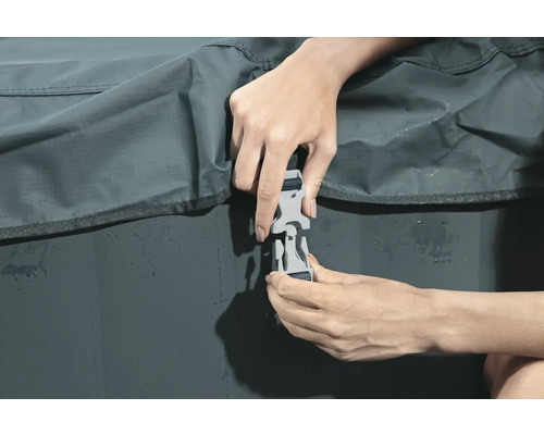 Eine Person befestigt einen Klickverschluss an einer Schutzhülle.