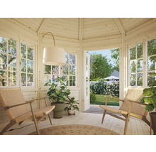 Helles Gartenhaus mit zwei Sesseln, Stehlampe und Pflanzen