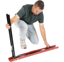 Mann montiert eine Fliesenschneidlehre aus Metall für große Fliesen