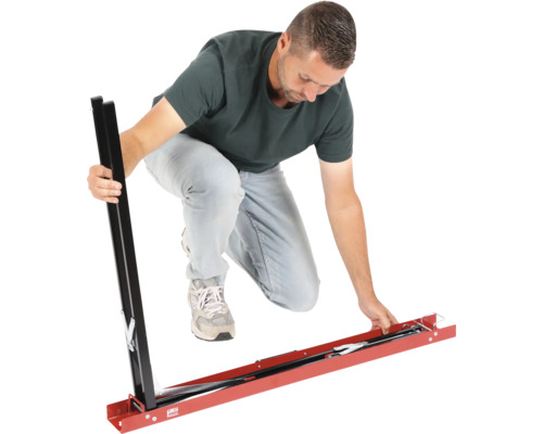 Mann montiert eine Fliesenschneidlehre aus Metall für große Fliesen