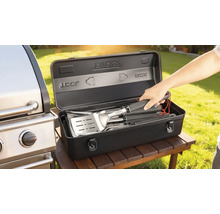 Grillbesteckset in einer schwarzen Aufbewahrungsbox neben einem Grill