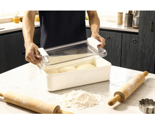Teigbehälter mit Deckel und zwei Nudelhölzern sowie Mehl auf einer Küchenoberfläche