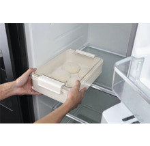 Person stellt eine Teigschüssel mit Deckel in den Kühlschrank