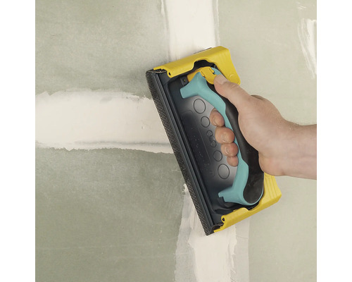 Handschleifer beim Schleifen einer Wand.