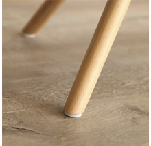 Detailaufnahme eines Möbelfußes aus Holz mit Bodenschoner.