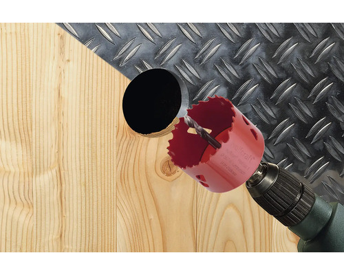 Eine Lochsäge bohrt ein Loch in ein Holzbrett.