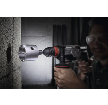 Bohrmaschine mit Bohrkrone beim Bohren eines Lochs in eine Betonwand.