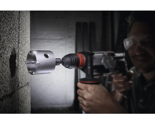 Bohrmaschine mit Bohrkrone beim Bohren eines Lochs in eine Betonwand.