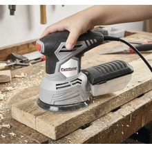 Eine Hand bedient einen Pattfield Exzenterschleifer auf einem Holzbrett.