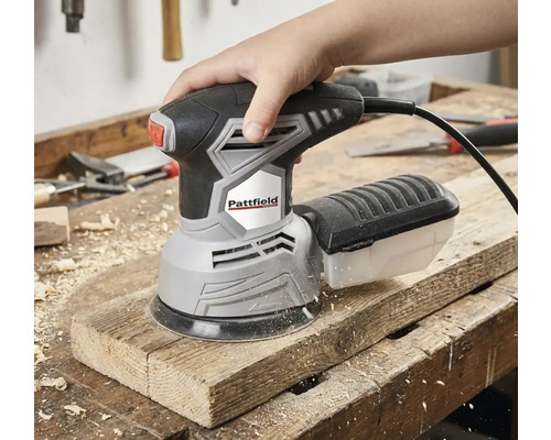 Eine Hand bedient einen Pattfield Exzenterschleifer auf einem Holzbrett.