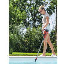 Frau reinigt einen Pool mit einem Poolreiniger mit Stiel.