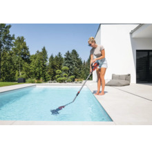 Frau reinigt Pool mit Poolsauger