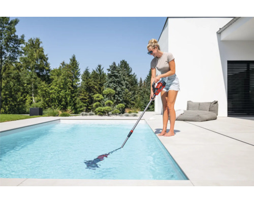 Frau reinigt Pool mit Poolsauger