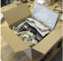 Akkubohrschrauber in einem offenen Karton mit Verpackungsmaterial