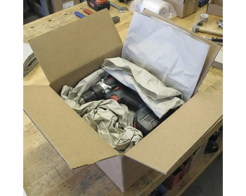Akkubohrschrauber in einem offenen Karton mit Verpackungsmaterial