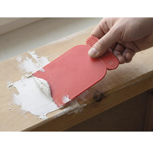 Handwerker verwendet einen Spachtel, um Fugenmasse aufzutragen.